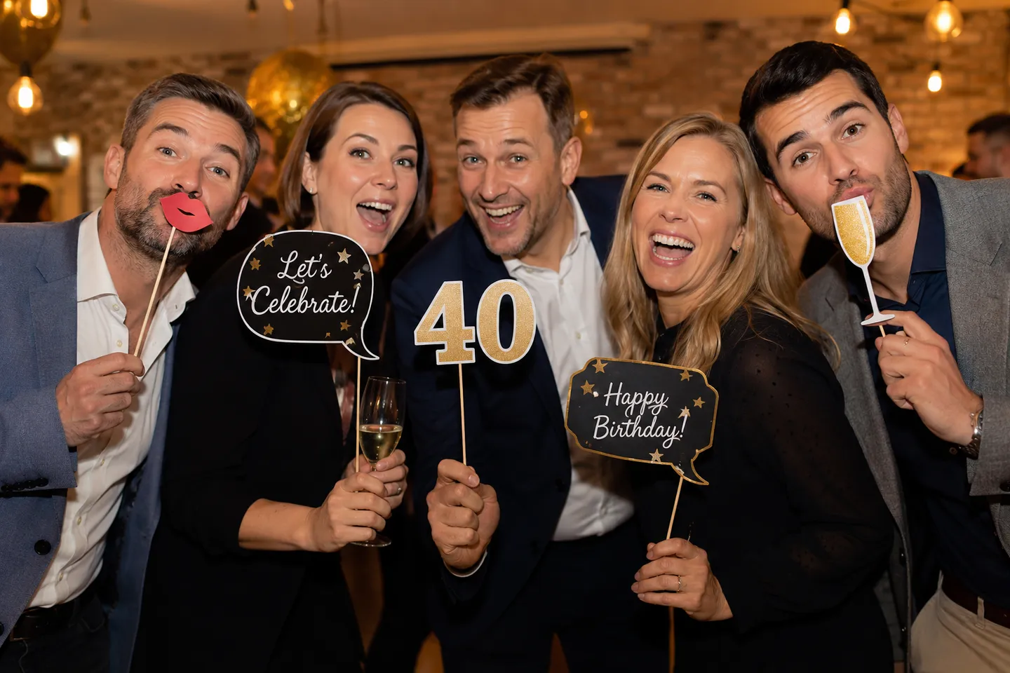 Eine Gruppe feiert einen 40. Geburtstag mit Fotobox-Requisiten.