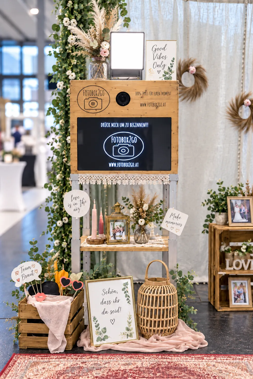 Unsere Holzfotobox mit eingeschaltetem Licht, Accessoires und Hochzeitsdekoration am Messestand.